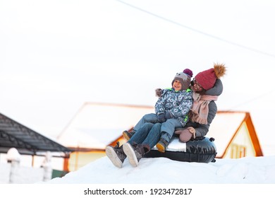 Family Mom And Child Winter Activity, Slide From Snow Hill Together On The Snow Tubing