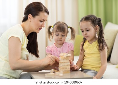 Family Mom And Daughters At The Table Playing Board Game