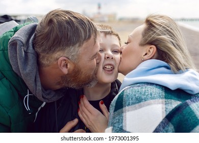 Family Mom And Father Kiss Teen Son On The Cheek Outside