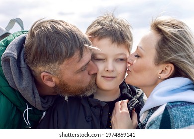 Family Mom And Father Kiss Teen Son On The Cheek Outside