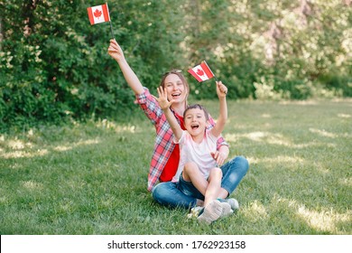 Family Mom With Son Celebrating National Canada Day On 1st Of July. Caucasian Mother With Child Boy Waving Canadian Flags. Proud Citizens Celebrate Canada Day In Park Outdoor. 