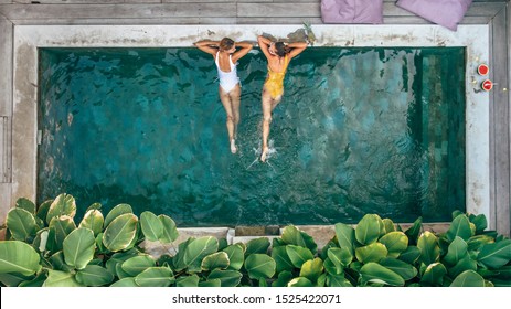 Mãe de família e filho adolescente relaxando na piscina na villa privada de Bali, vista superior de cima