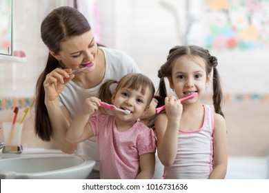 Family Mom And Two Daughters Little Girls Brush Their Teeth