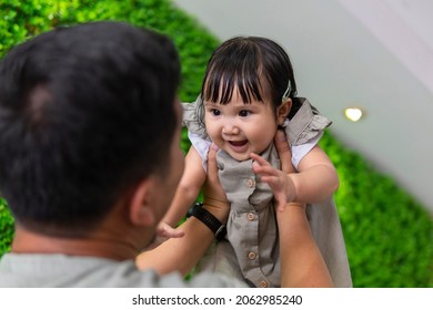 Family Moment: Father Holding Holding Baby Up In The Air