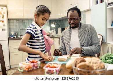 Family morning. Good-looking father and daughter enjoying their family morning cooking together - Shutterstock ID 1291962355