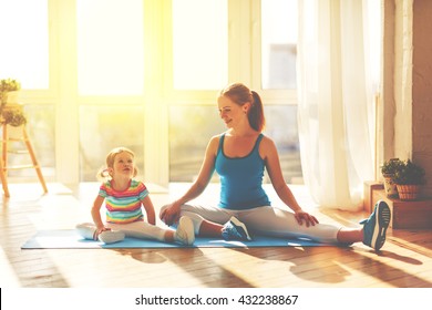 Family Mother And Child Daughter Are Engaged In Fitness, Yoga, Exercise At Home