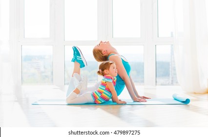 Family Mother And Child Daughter Are Engaged In Fitness, Yoga, Exercise At Home