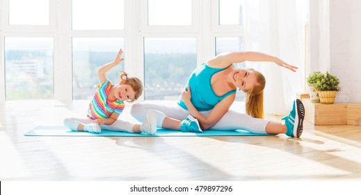 Family Mother And Child Daughter Are Engaged In Fitness, Yoga, Exercise At Home