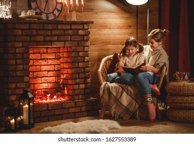 family mother and child daughter reading book and drink tea on winter evening by fireplace
 - Powered by Shutterstock