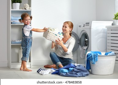 Family Mother And Child Girl Little Helper In Laundry Room Near Washing Machine And Dirty Clothes