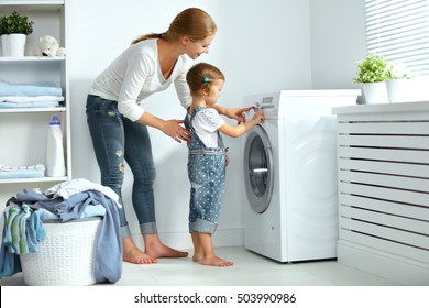 Family Mother And Child Girl Little Helper In Laundry Room Near Washing Machine And Dirty Clothes