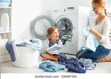 Family Mother And Child Girl Little Helper In Laundry Room Near Washing Machine And Dirty Clothes
