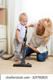 Family Mother And Child Have A Fun Cleaning Room With Hoover - Housework