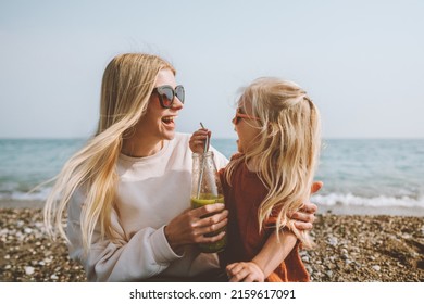 Family mother and daughter cheerful laughing travel outdoor summer vacations mom and child drinking smoothie on beach healthy lifestyle vegan organic beverage  - Powered by Shutterstock