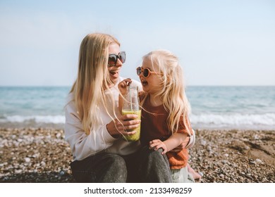 Family mother and daughter child drinking smoothie on beach healthy lifestyle vegan organic food travel vacations summer holidays outdoor happiness emotions cheerful people - Powered by Shutterstock