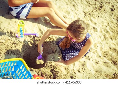 Family Mother And Daughter Having Fun On Beach. Parent Mom And Child Kid Digging Hole In Sand. Summer Vacation Holidays Relax.