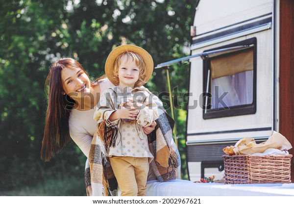 Family mother and daughter in nature relax traveling
in a trailer, a motor
home