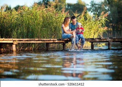 Family, Mother, Father And Child Playing And Spending Time With His Young Son In The Summer The River Or Lake