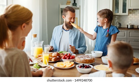 Family Mother Father And Children Have Breakfast In The Kitchen In Morning
