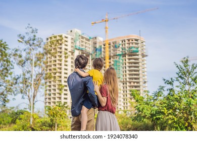 Family mother, father and son looking at their new house under construction, planning future and dreaming. Young family dreaming about a new home. Real estate concept