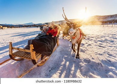 Familia madre y su hija en safari de renos en el soleado día de invierno en el norte de Noruega