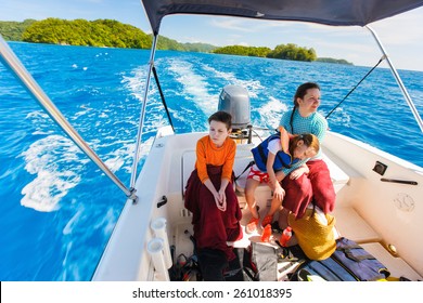 Family Of Mother And Her Kids At Small Boat On Private Water Tour Or Excursion