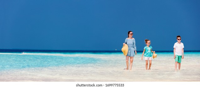 Madre familiar e hijos disfrutando de unas vacaciones en la playa tropical, el panorama es perfecto para las banderas