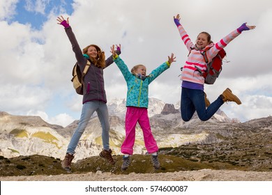 family - mother and two daughters  girls sisters hikers at the mountains Dolomites, Italy. Tre Cime di Lavaredo