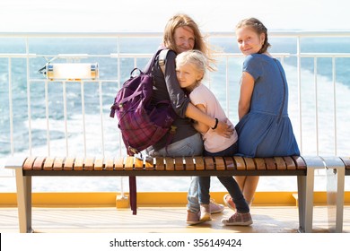 Family - Mother And Two Daughters Sitting On A Bench On The Ferry And The Sea In The Background
