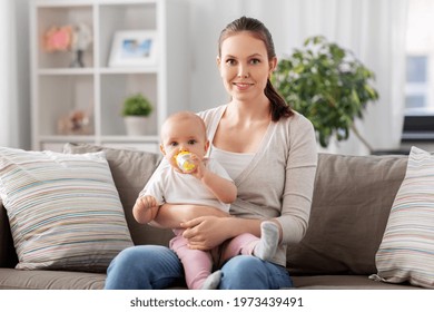 Family, Motherhood And People Concept - Close Up Of Mother With Little Baby Drinking Water From Sippy Cup At Home