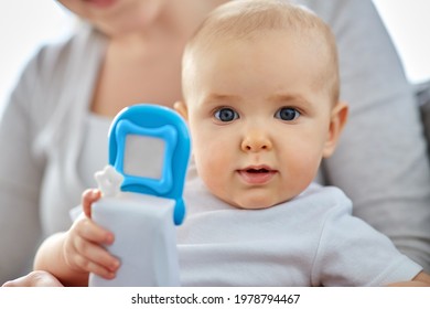 Family, Motherhood And People Concept - Close Up Of Mother And Little Baby Playing With Toy Phone At Home