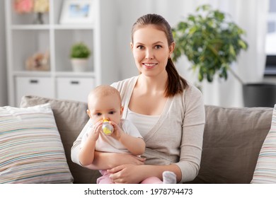 Family, Motherhood And People Concept - Close Up Of Mother With Little Baby Drinking Water From Sippy Cup At Home