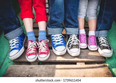 A family in multi-colored sneakers, children and parents.