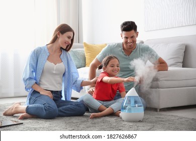 Family near modern air humidifier at home