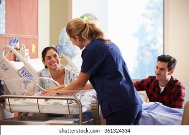 Family And Nurse With New Born Baby In Post Natal Department