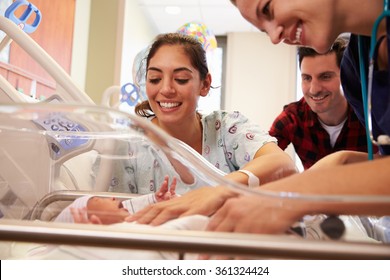 Family And Nurse With New Born Baby In Post Natal Department