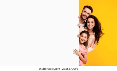 Family offer. Excited european parents and their daughter peeking out of blank white placard board with free space for your advertisement and design, banner - Powered by Shutterstock