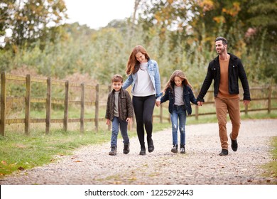 Family On Autumn Walk In Countryside Together