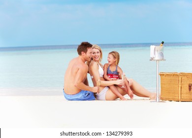 Family On Beach With Luxury Champagne Picnic