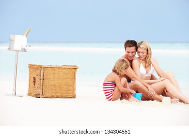 Family On Beach With Luxury Champagne Picnic