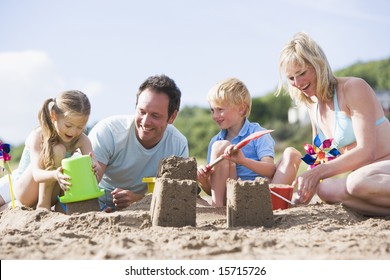 Family On Beach Making Sand Castles Smiling