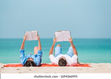 Family on the beach relaxing and reading books - Powered by Shutterstock