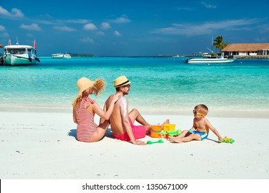 Family on beach, young couple with three year old boy. Woman applying sun screen protection lotion on man's back. Summer vacation at Maldives. - Powered by Shutterstock