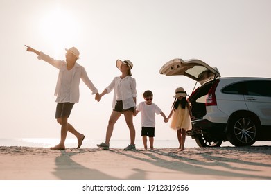 Family on the beach.Vacation time. Happy father, mother and son enjoying road trip the summer holidays.Parents and children are sitting on a hatchback with a sea background.