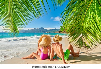 Family On Beautiful Anse Soleil Beach With Palm Tree, Young Couple With Three Year Old Toddler Boy. Summer Vacation At Seychelles, Mahe.