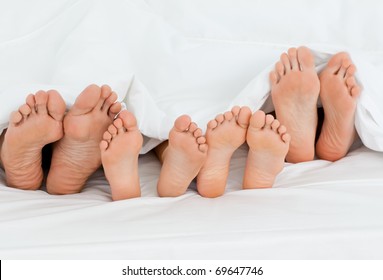  Family on the bed  at home with their feet showing