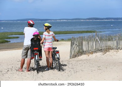 Family On A Biking Journey Making A Stop On The Beach