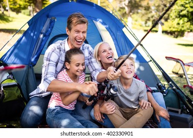 Family on a camping trip fishing outside their tent - Powered by Shutterstock