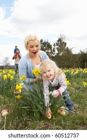 Family On Easter Egg Hunt In Daffodil Field