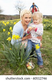 Family On Easter Egg Hunt In Daffodil Field